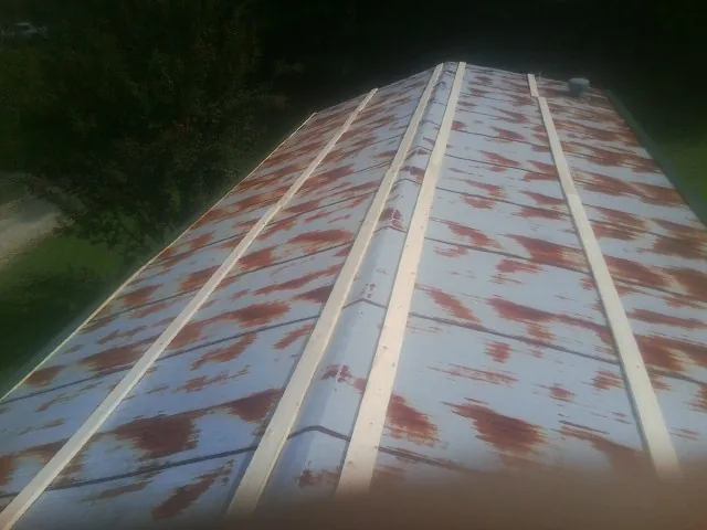 Rusted metal roof panels with new wood purlins before replacement — Storm Damage Roof Repair in Drain by Roofing Brothers