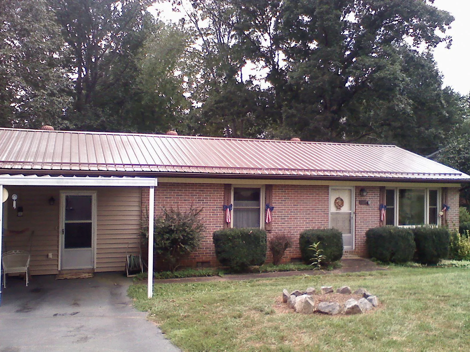 Bronze metal roof and carport on a brick ranch home — Roof Repair work by our crew in Drain